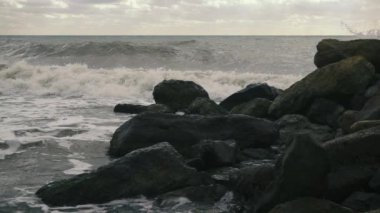 Büyük dalgalar rulo ve kayalar yavaş hareket karşı crash
