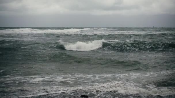 Slow motion gray stormachtige zee en in de verte een surfer — Stockvideo