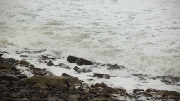 Ondas de espuma na costa pedregosa slow mo — Vídeo de Stock