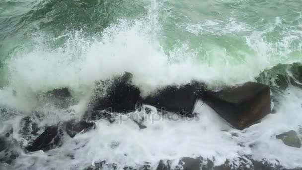 Lento mo la ola se rompe contra las piedras cuadradas de un rompeolas — Vídeos de Stock