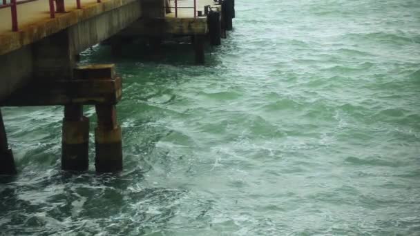Rusteloos water in de buurt van een betonnen pier slow motion — Stockvideo