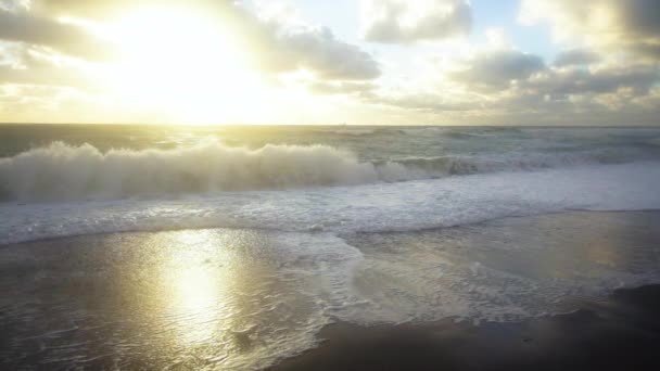 Повільний момент, коли хвиля врізається в берег під час заходу сонця — стокове відео