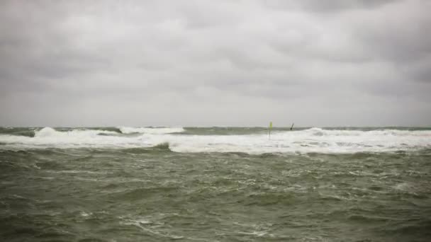 Windsurfer in orangefarbener Jacke im Meer — Stockvideo