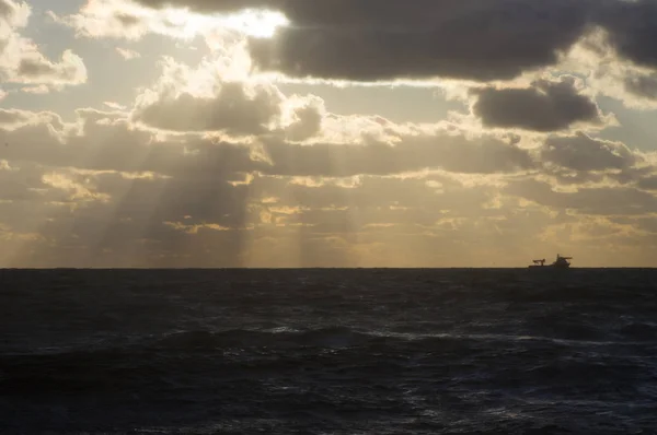 Statek na horyzoncie w morze o zachodzie słońca — Zdjęcie stockowe