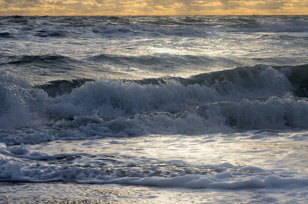 Pequenas ondas em um rolo de mar conturbado para a costa — Fotografia de Stock