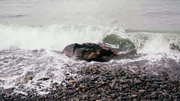 A onda se divide lindamente contra a pedra na costa slow mo — Vídeo de Stock