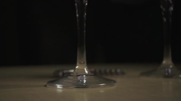 Du vin rouge au ralenti est versé dans un verre sur la table — Video