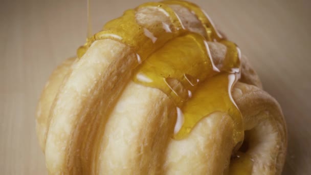 En cámara lenta verter un croissant de miel — Vídeos de Stock