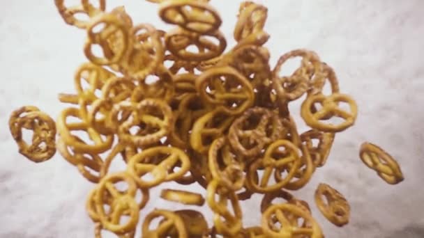 Un montón de pretzels caen de debajo de las cámaras lento mo — Vídeo de stock