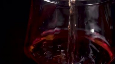 Şarap akıntısı Dekanter cam ve kabarcıklarına dökülüyor.