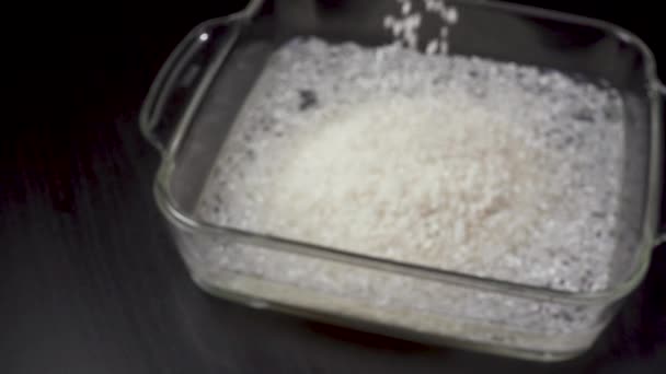 El arroz se vierte en un recipiente de vidrio — Vídeos de Stock