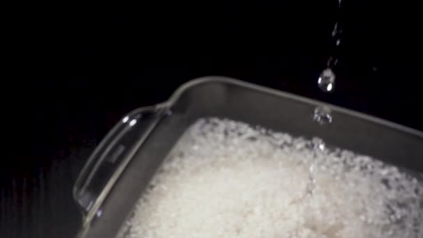 Вода наливается в миску с рисом — стоковое видео