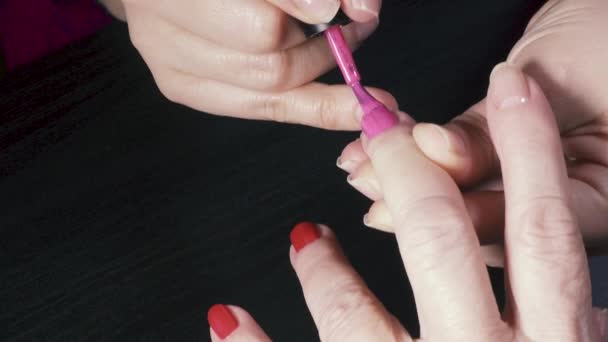 Manikiurzystka obejmuje paznokcie lakierem — Wideo stockowe