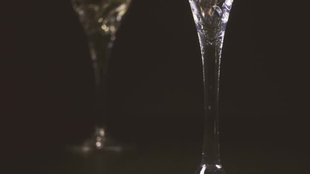 Witte wijn mondt uit in het glas van de wijn. De stijgingen van de camera. — Stockvideo