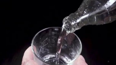 El bir cam şişe ağır çekim üzerinden su akar tutar
