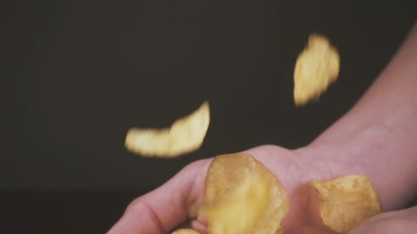 Batatas fritas em câmara lenta caem nas palmas das mãos abertas do rapaz — Vídeo de Stock