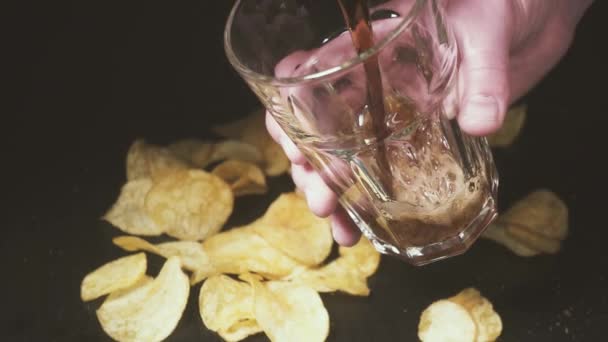 Cola giet in een glas over chips slow motion — Stockvideo