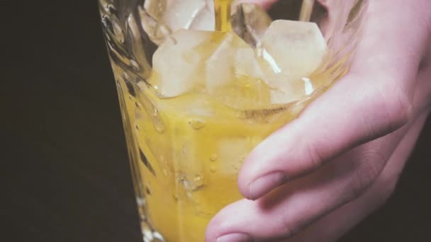 La main des garçons tient un verre sur la table et verse du soda au ralenti 