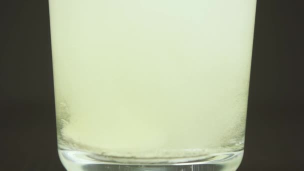 Bulles provenant de comprimés effervescents dans un verre au ralenti 