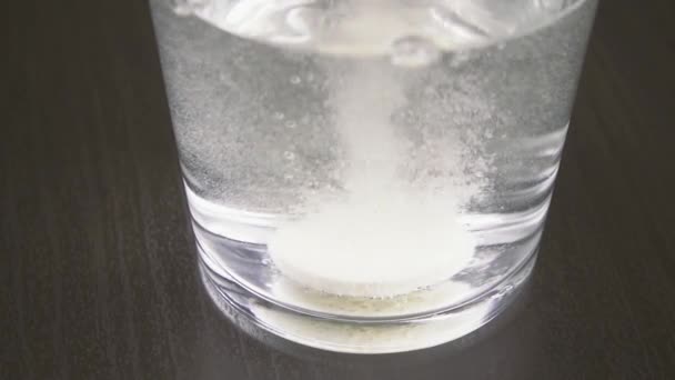 टॅब्लेट पाणी हळू चळवळीसह एका ग्लासमध्ये विरघळते — स्टॉक व्हिडिओ