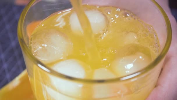 Ice floats in a glass with orange soda — Stock Video