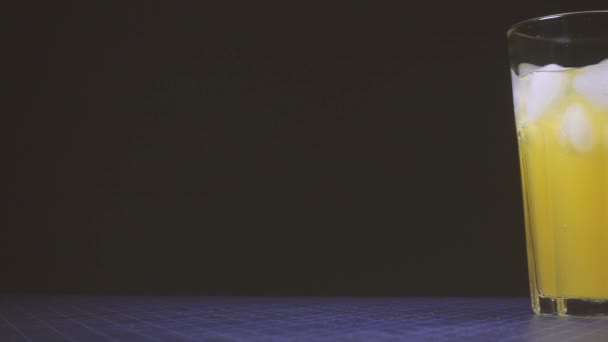 Caméra se déplace le long de la table avec un verre de boisson orange 