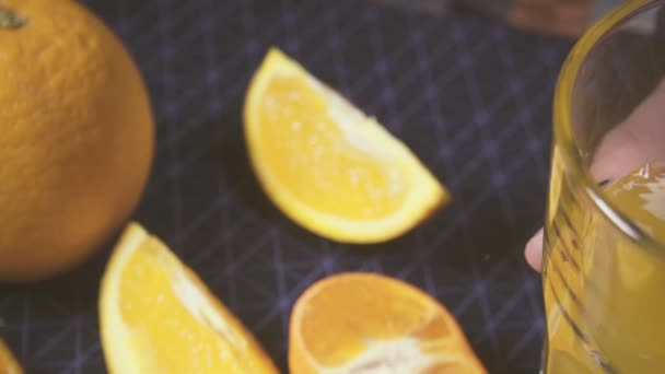 Mouvement de la caméra sur un verre avec une boisson orange au ralenti — Video