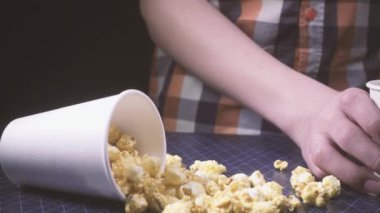 Ağır çekim masaya patlamış mısır dağınık ve çocuk bir kola dökülen