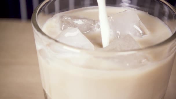 Närbild mjölk hälls i isen — Stockvideo