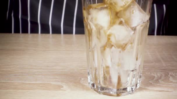 Koffie wordt gegoten in een glas met ijs — Stockvideo