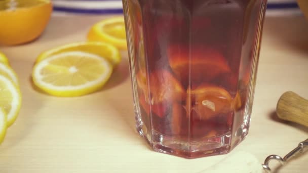 Ice falls into a glass of sangria — Stock Video