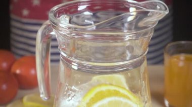 Ağır çekim buz sürahi portakal dilimleri düşüyor