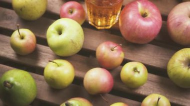 Ağır çekim kamera elmalardan masanın üstüne bir bardak meyve suyu taşır