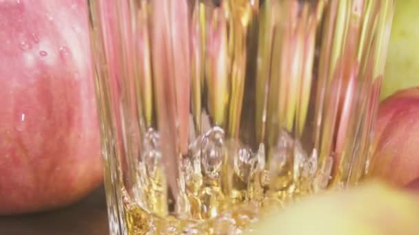 Le jus de pomme est versé dans un verre de la boîte au ralenti 