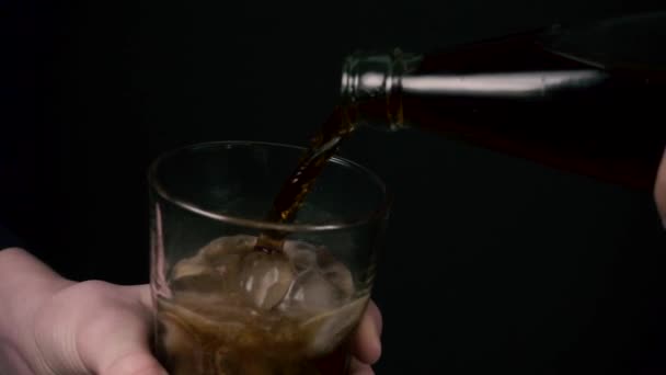 The boy is holding a glass with ice and the woman is pouring cola slow motion — Stock Video