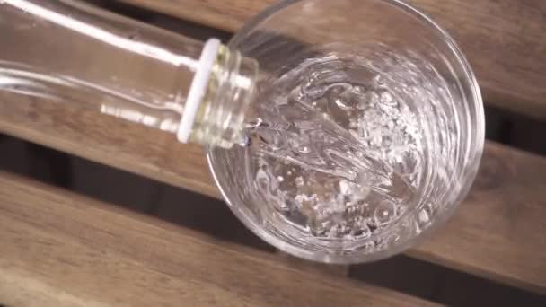 Slow motion vatten med bubblor i en glas ovanifrån — Stockvideo