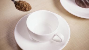 Bir kaşık ile bir kadının elinde kahve bir fincan yavaş hareket dökme