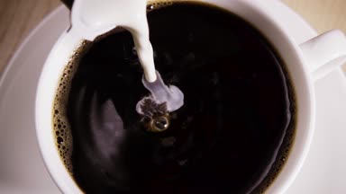 Bir kupa kahve ile içine yavaş krem dökülen