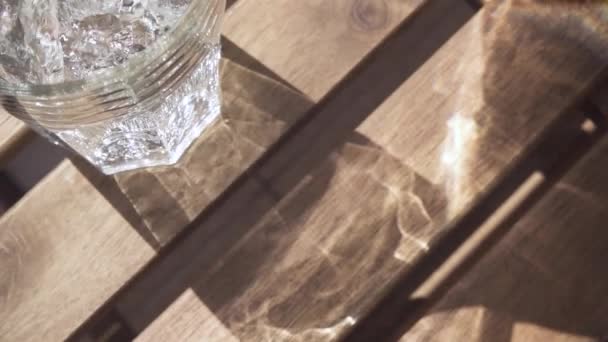 테이블에 유리에 슬로우 모션 깨끗 한 물 흐름 — 비디오