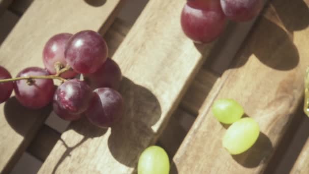 Медленное движение камеры движется по столу с виноградом и напитком в стакане — стоковое видео