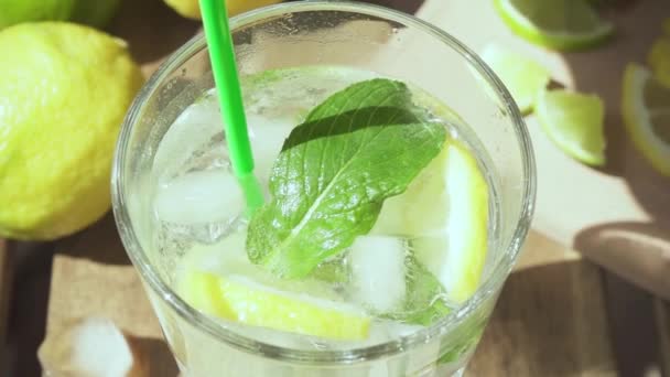 Slow motion in a glass with lemonade put a cocktail straw — Stock Video