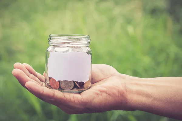 Hands holding money in the jar — Stock Photo, Image