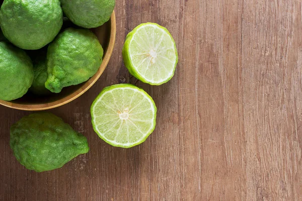 Fresh bergamot and bergamot slice in wooden bowls — Stock Photo, Image