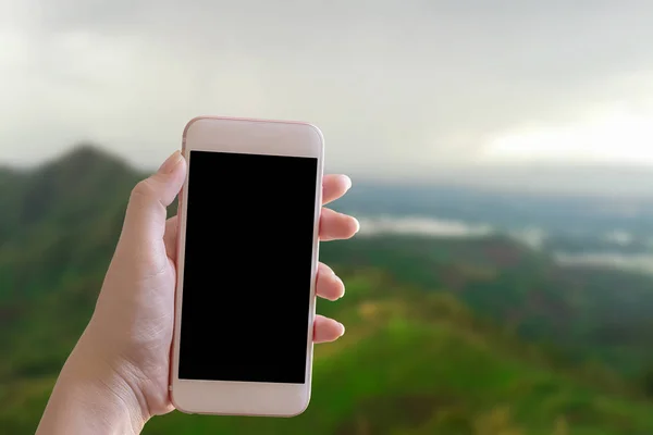 Ruka držící chytrý telefon s rozmazaným pozadím — Stock fotografie