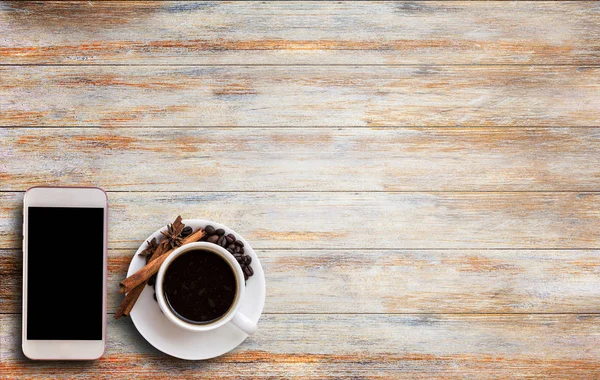 Смартфон и кофе на деревянном столе — стоковое фото