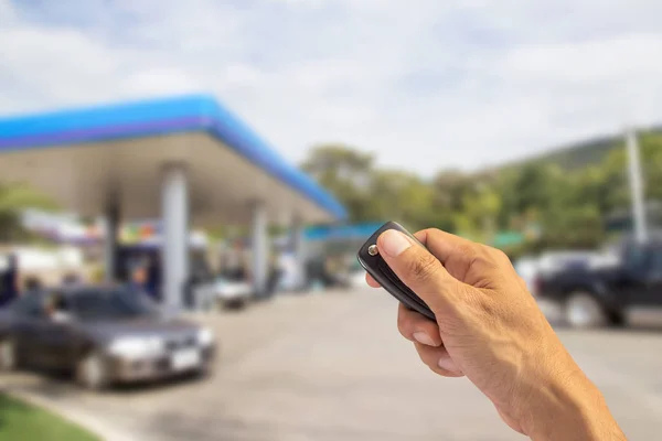 Mão segurando chave do carro isolado no fundo branco — Fotografia de Stock