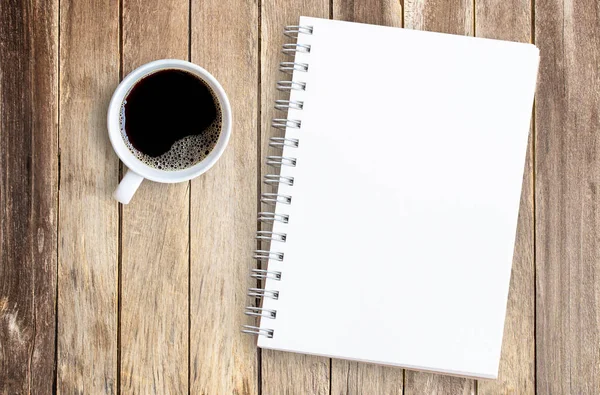 Tasse de café et cahier sur table de bureau en bois . — Photo