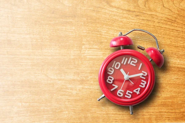 Reloj despertador rojo sobre fondo de madera marrón antiguo . — Foto de Stock