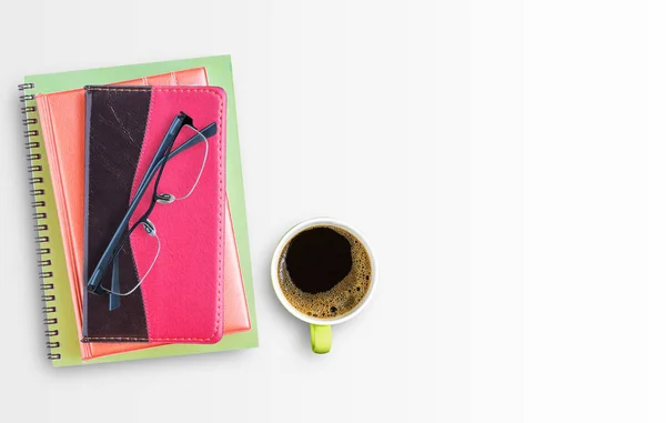 Caderno e copos com xícara de café na mesa de escritório — Fotografia de Stock