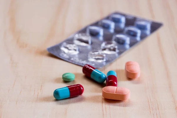 Tabletki i tabletki na drewnianym stole — Zdjęcie stockowe